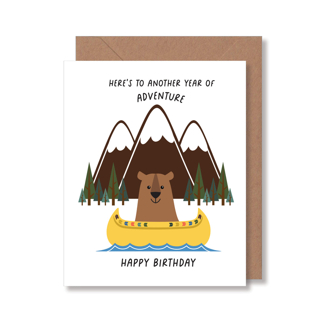 Adventure birthday card featuring an illustration of a bear canoeing on a mountain lake designed for nature lovers.