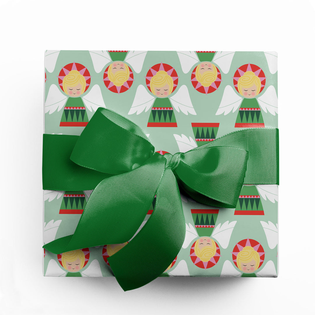 Gift wrapped in wrapping paper featuring a Christmas angel pattern with green ribbon by Gigglemugg.