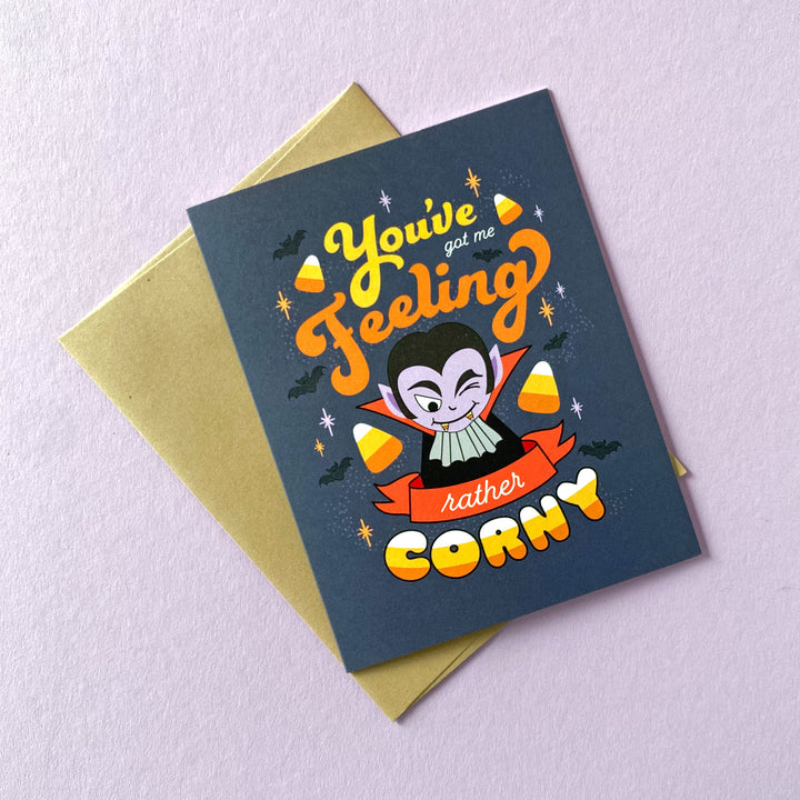 Halloween greeting card card featuring a fun vampire illustration and lettering saying, you've got me feeling rather corny designed by Gigglemugg