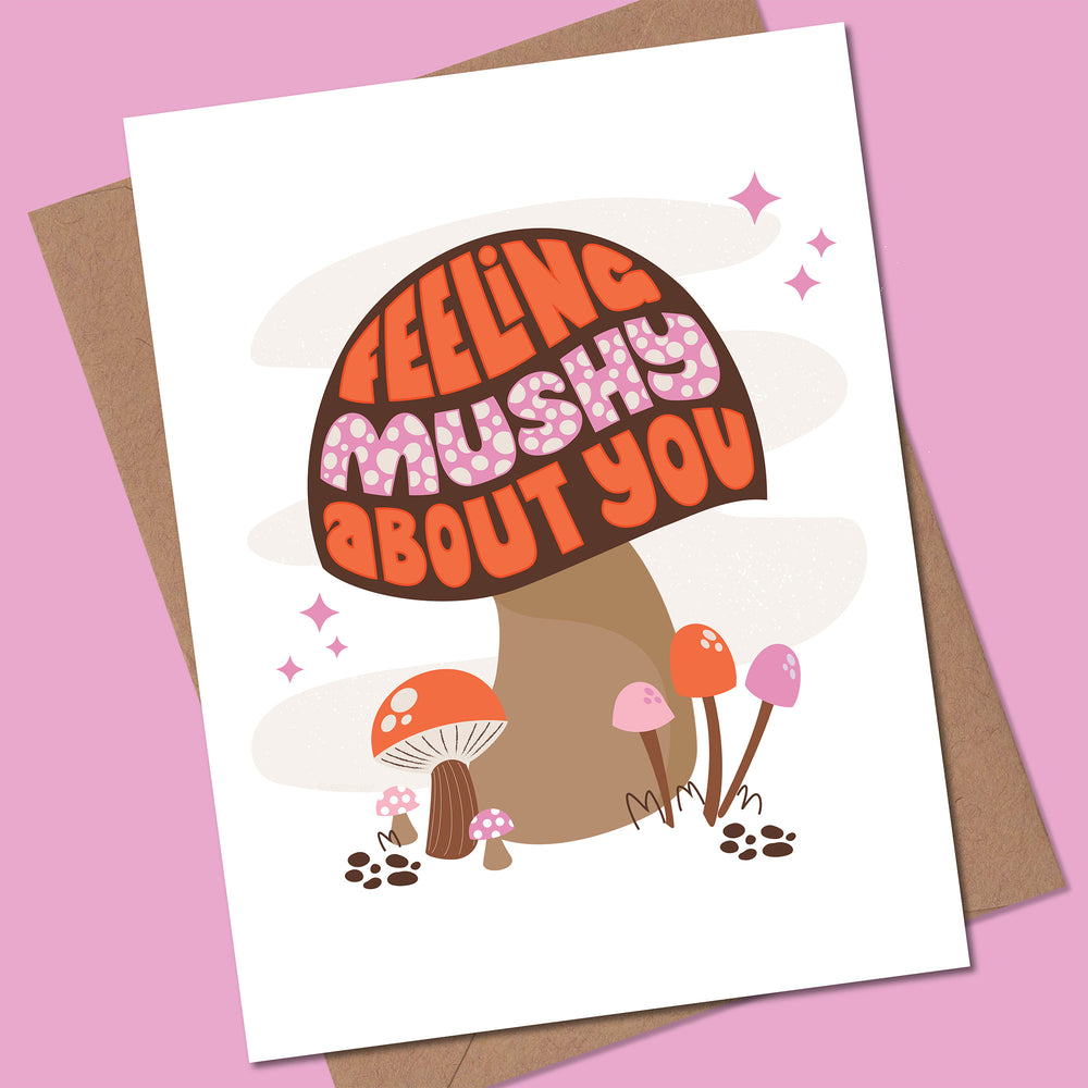 Greeting card with mushroom illustration and text 'Feeling mushy about you' on a pink background