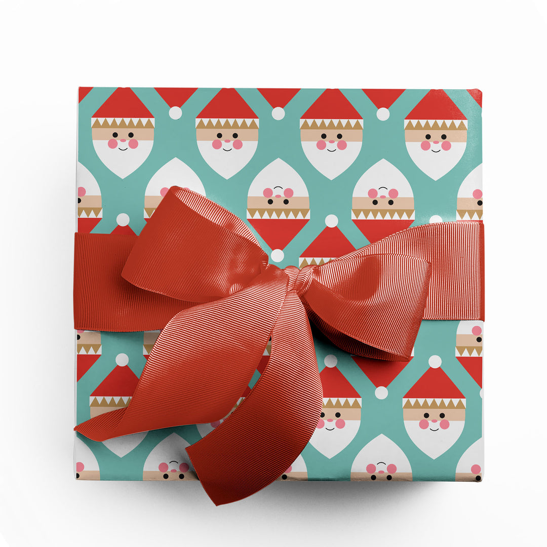 Christmas gift wrapped in a modern, geometric Santa wrapping paper by Gigglemugg.