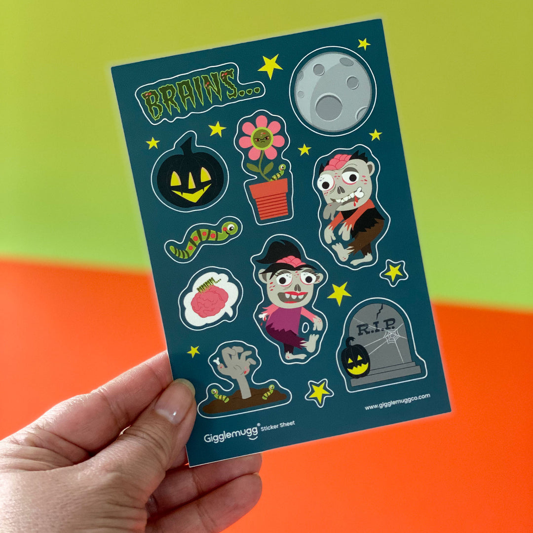 Vinyl zombies sticker sheet featuring fun zombie graveyard illustrations, zombie plants, headstone, moon, jack-o-lantern, worm, and stars designed by Gigglemugg.