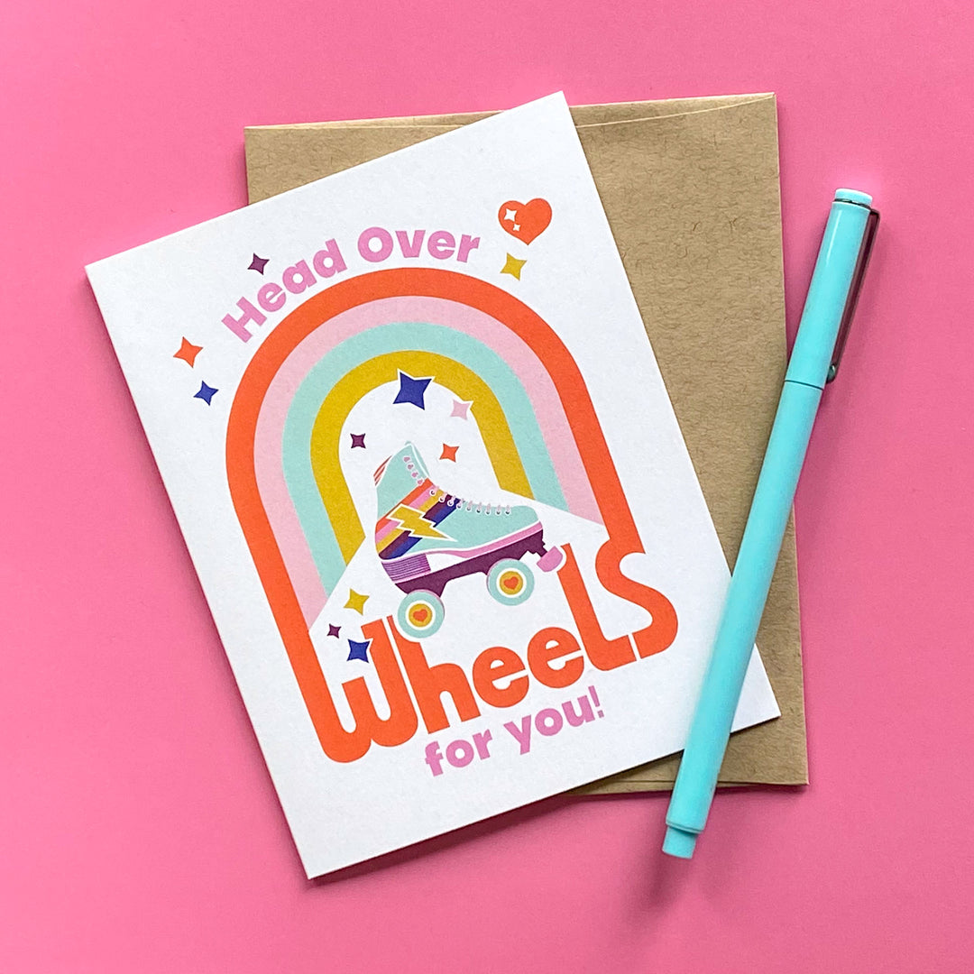 Greeting card with rainbow design and text on a pink background