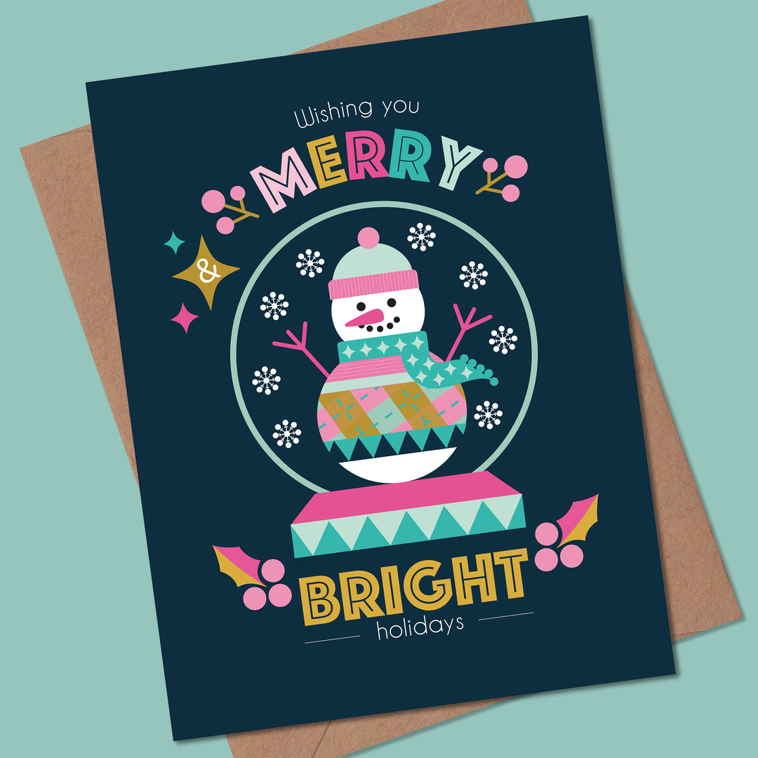 Christmas card with a snowman in a snow globe and colorful text on a blue background.