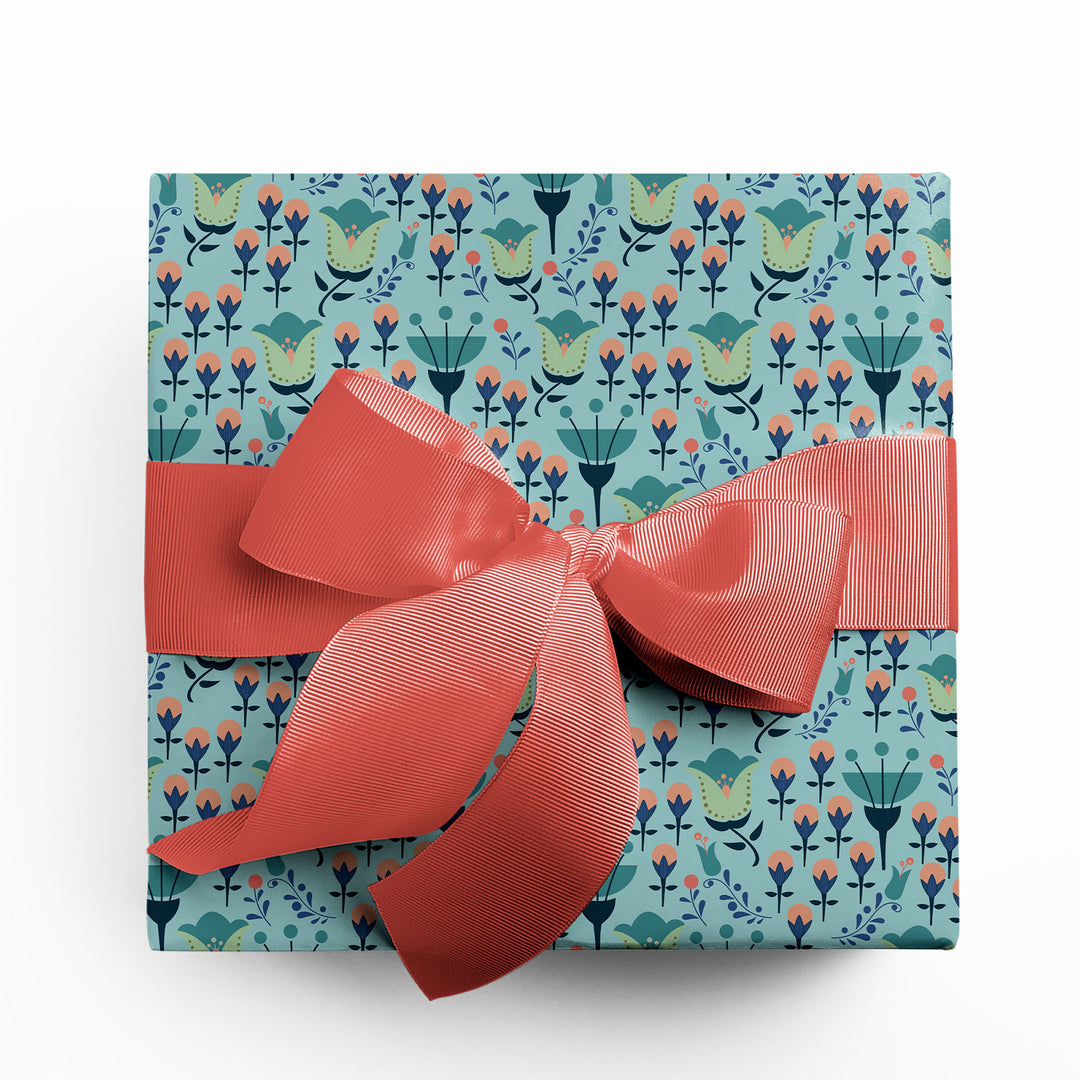 Gift wrapped in modern floral wrapping paper with coral colored ribbon by Gigglemugg.