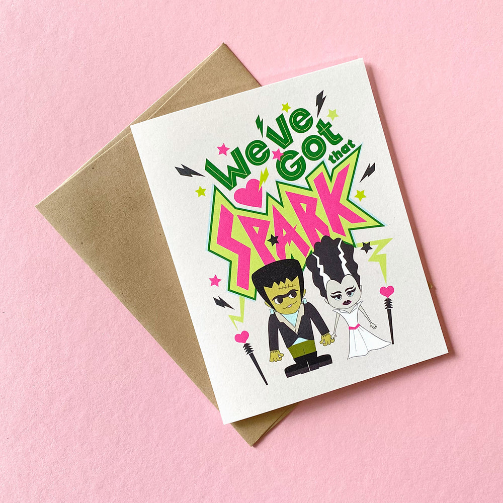 Love greeting card featuring a fun Frankenstein and his bride illustration and hand-lettered saying, "We've got that spark" by Gigglemgg®.