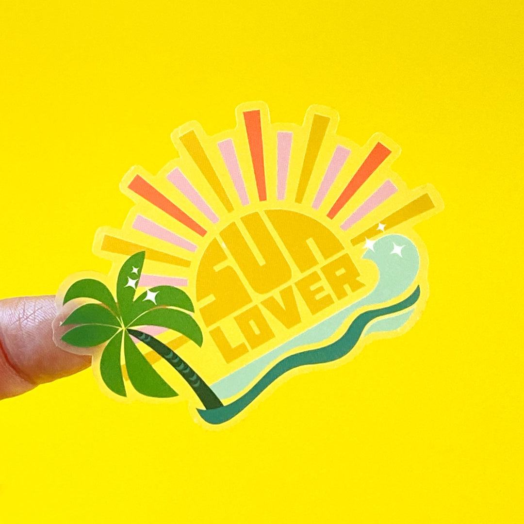 Sticker with 'Sun Lover' design featuring a palm tree and sun on a yellow background