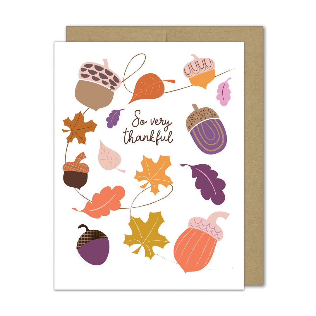 Greeting card with autumn-themed design featuring acorns and leaves on a white background.