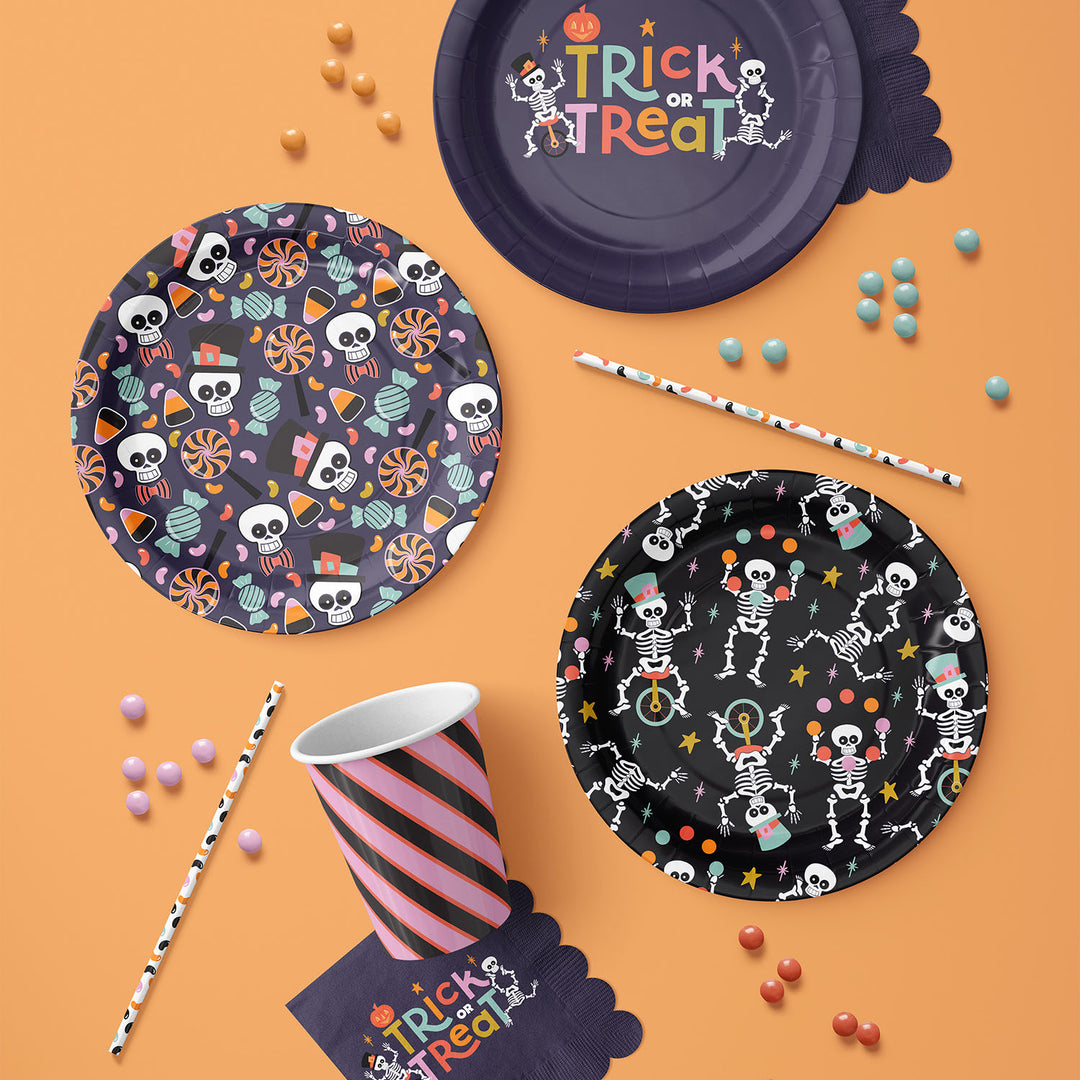 Halloween-themed paper plates, cups, and straws on an orange background by ©Gigglemugg