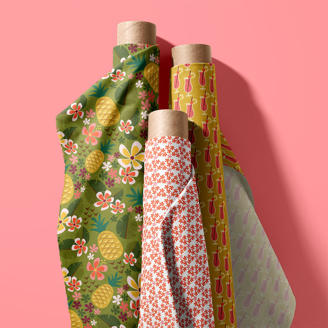 Rolls of colorful fabric with tropical pattern designs on a pink background by ©Gigglemugg